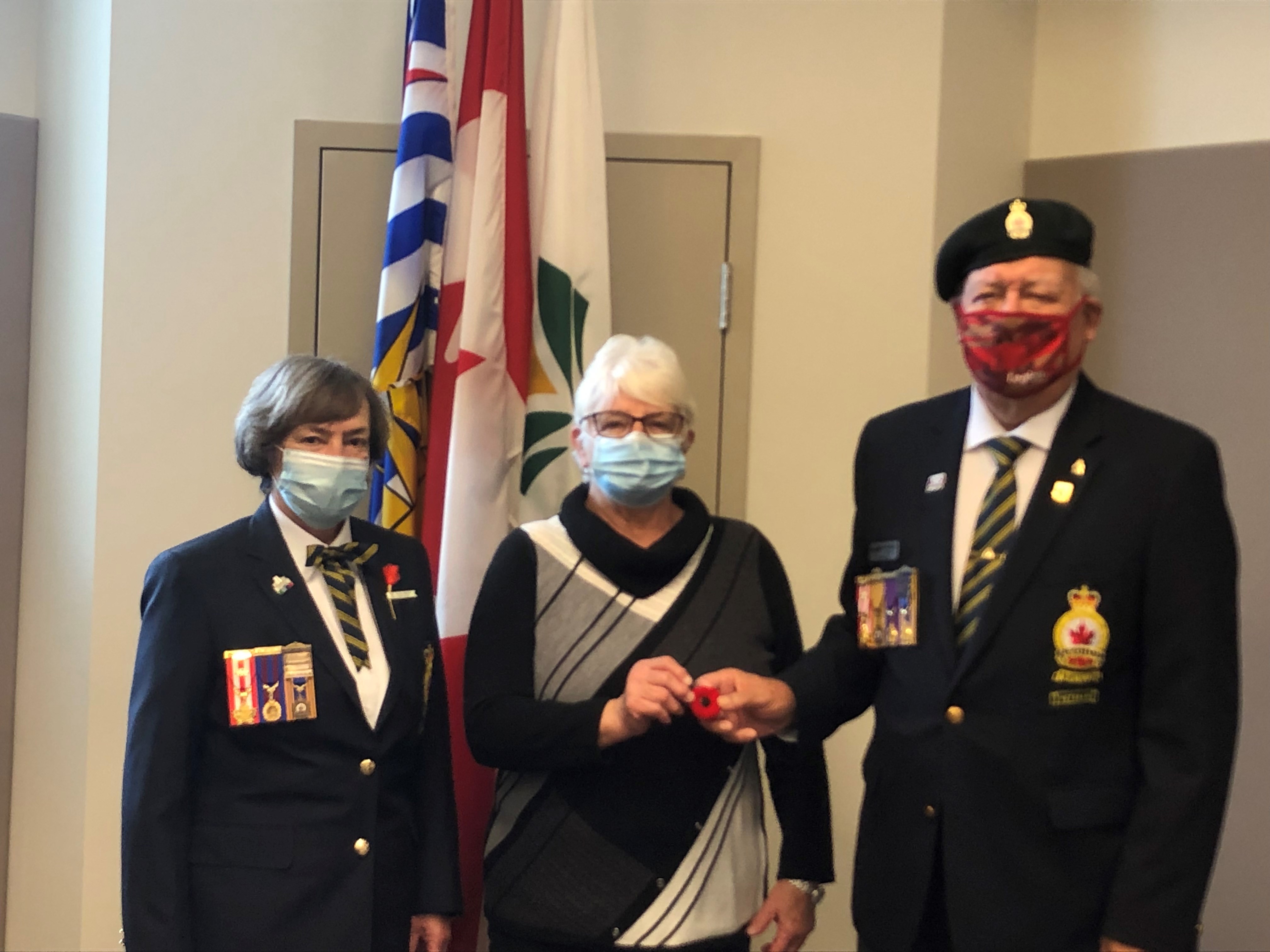 Mayor and Legion members stand in front of flags