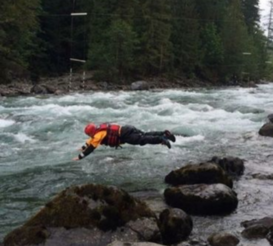 Team member diving into swift water
